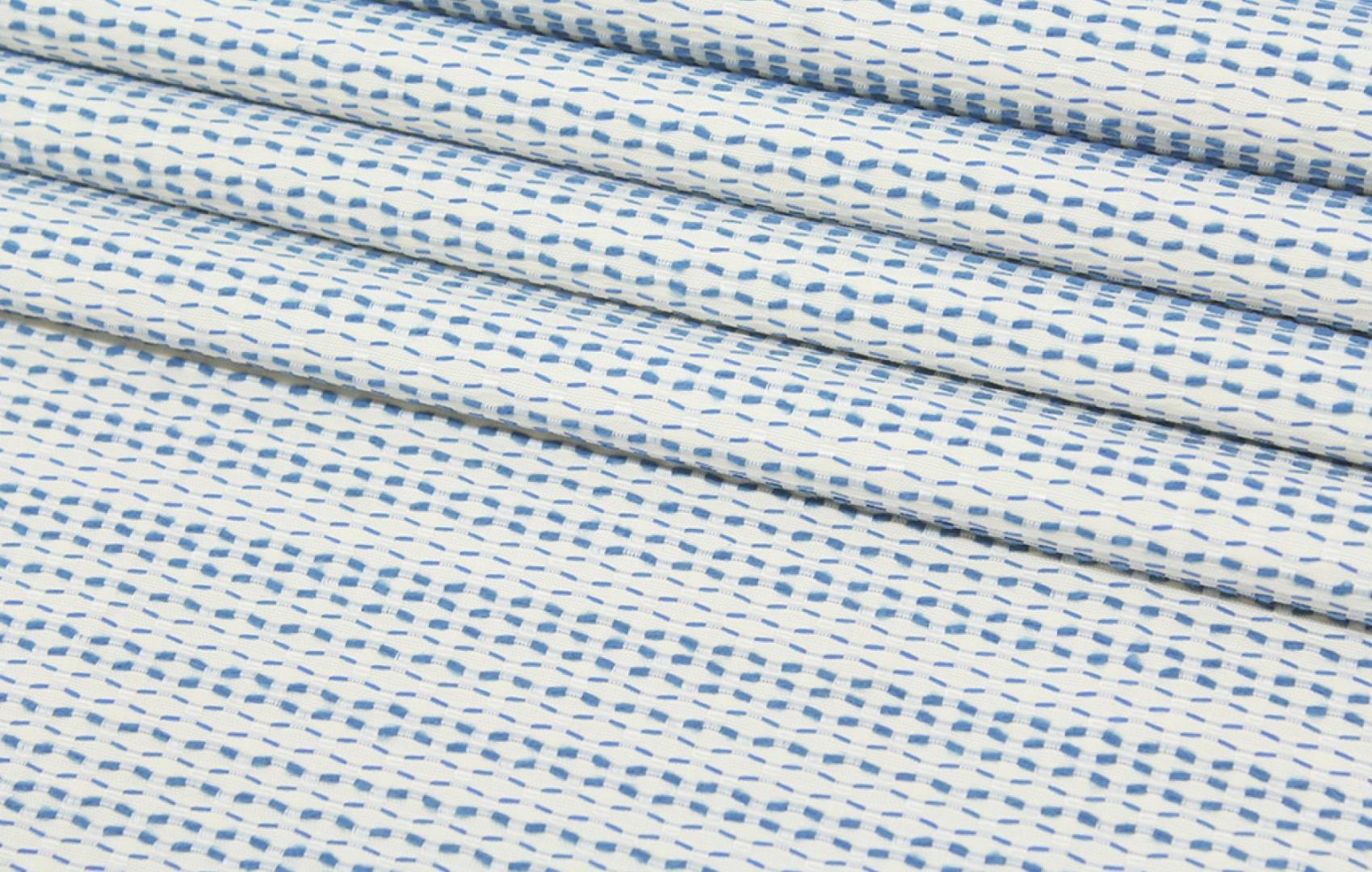 Close-up of a blue and white patterned 100% high UV polyester fabric.