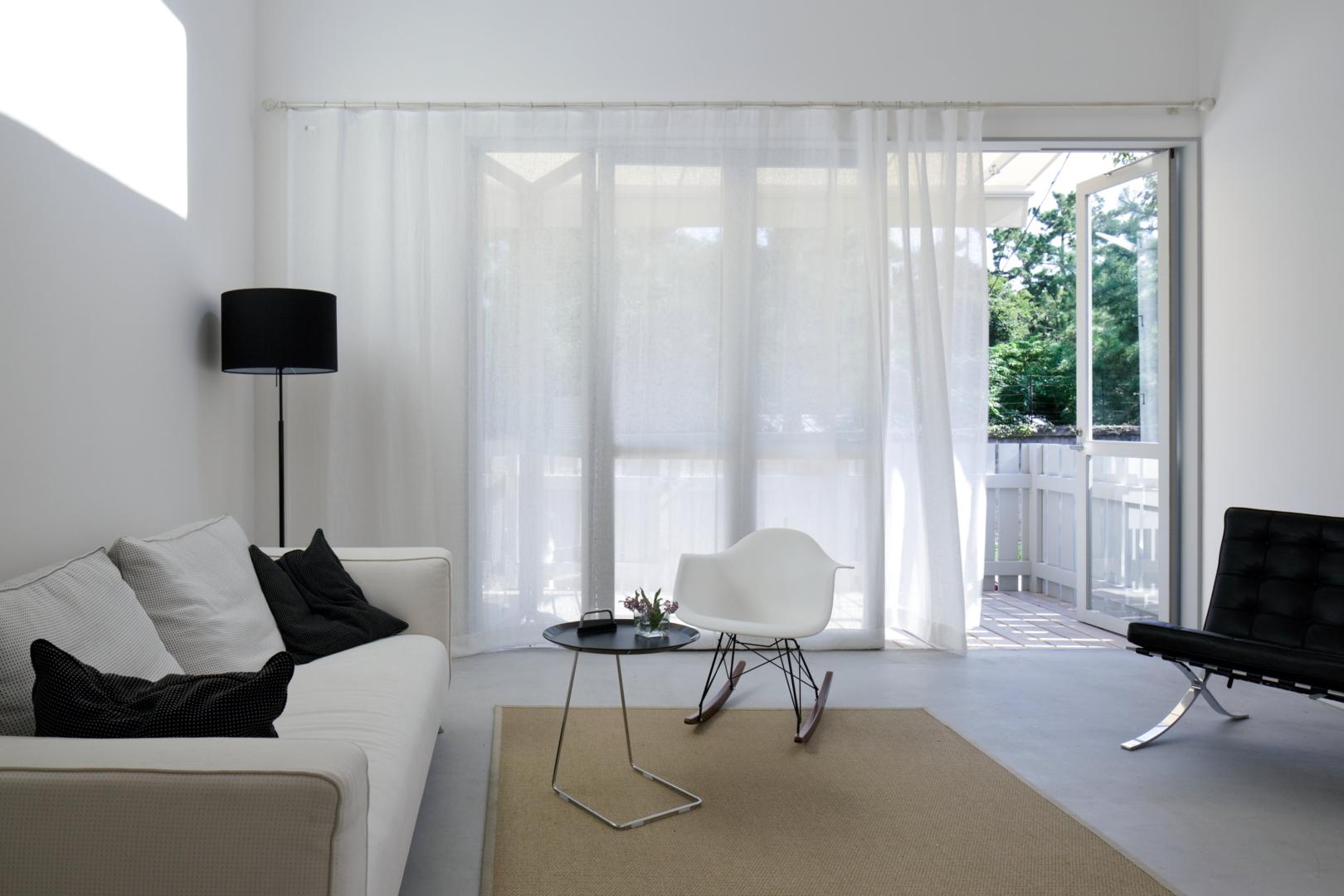 A bright living room with white sheer curtains.