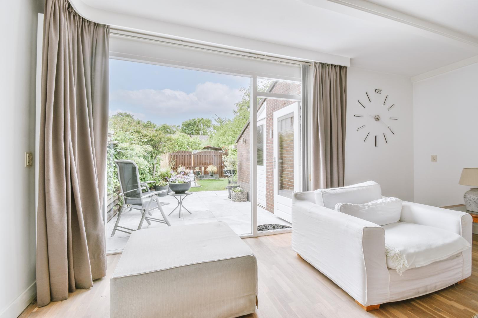 A modern living room with large sliding doors opening to a patio.