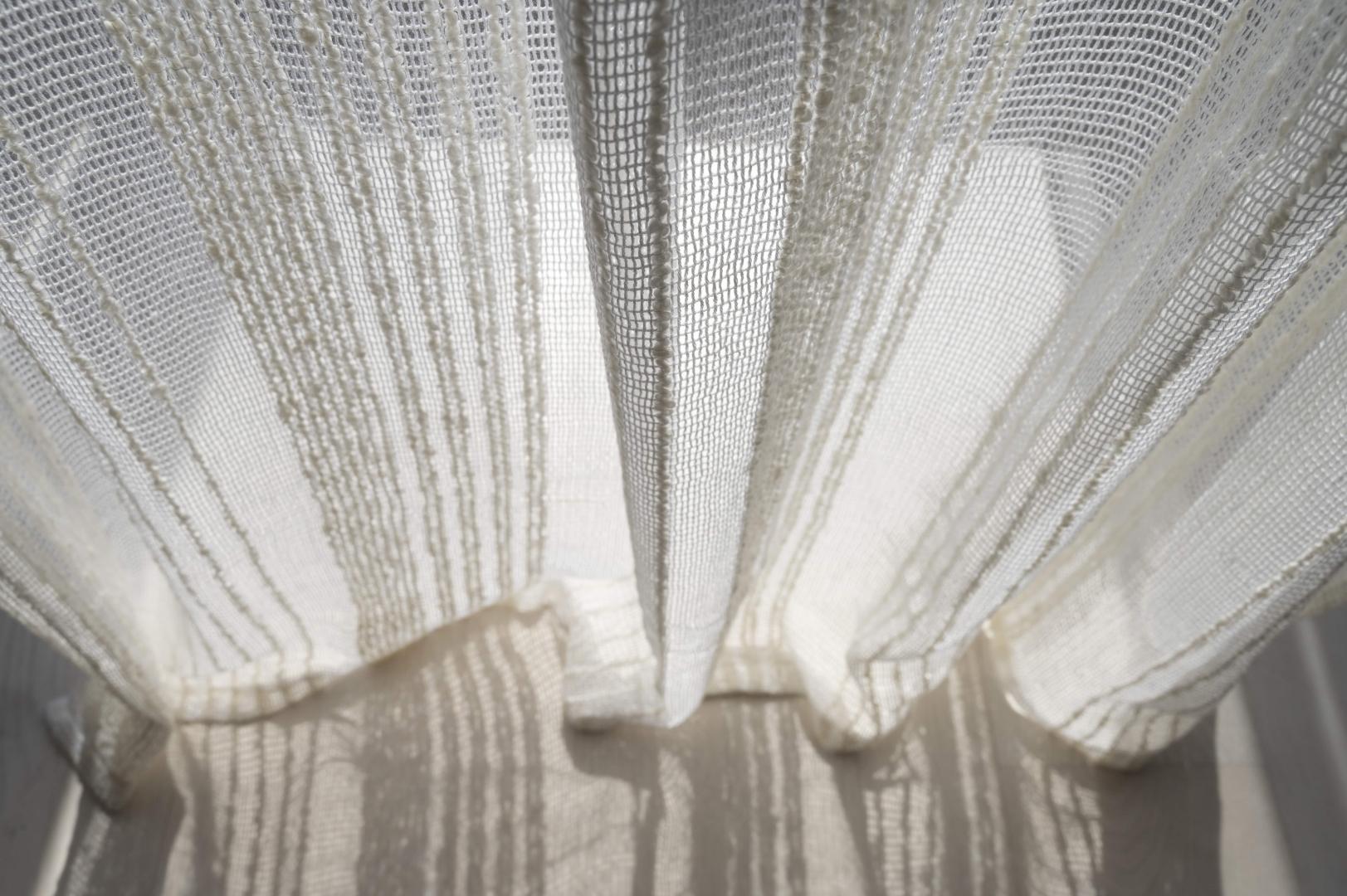 A close-up of white linen curtains.
