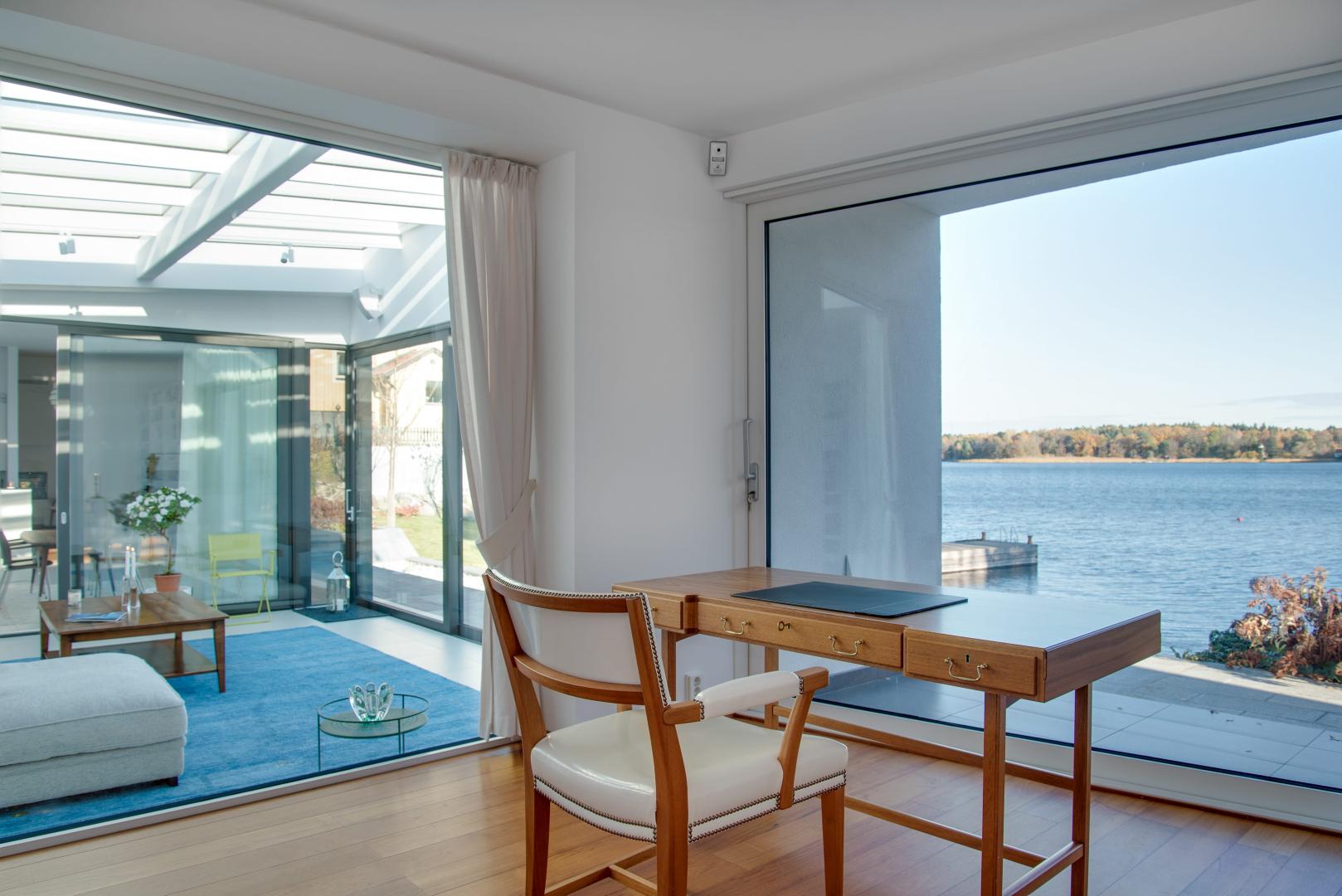 A luxury beach house with large glass windows and light curtains.