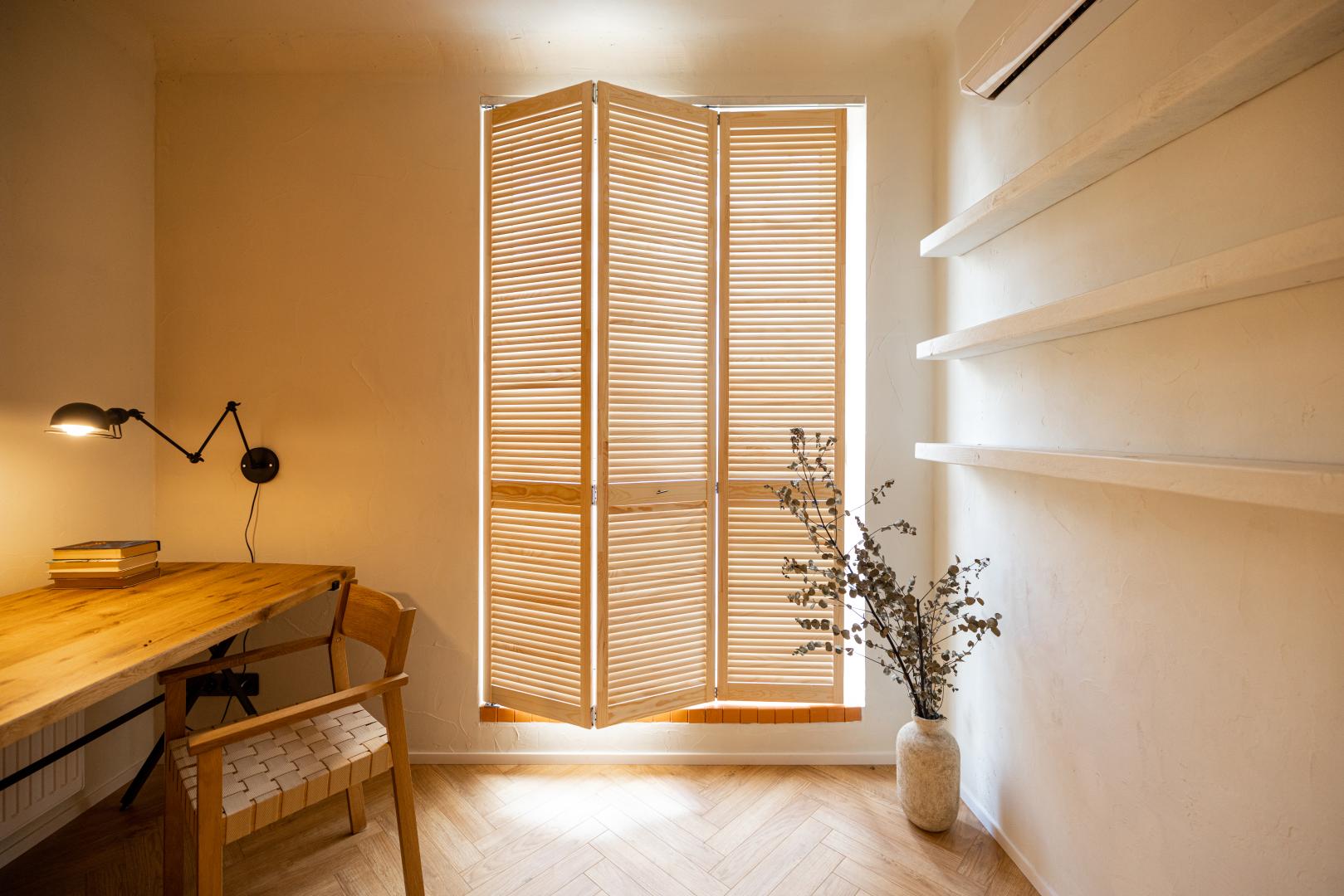 A room with a small table and shutters.