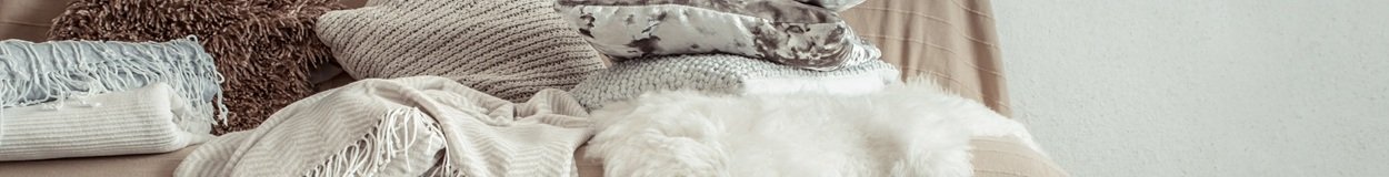 Modern interior of the living room with a sofa and decorative items . Decorative pillows and blankets. Coziness and comfort at home .