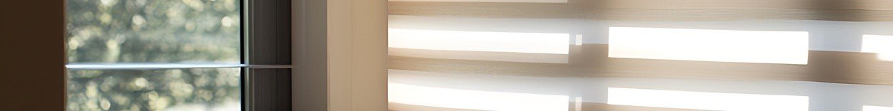 A cozy corner with a chair, a book, a pillow, and sunlight streaming through blinds.
