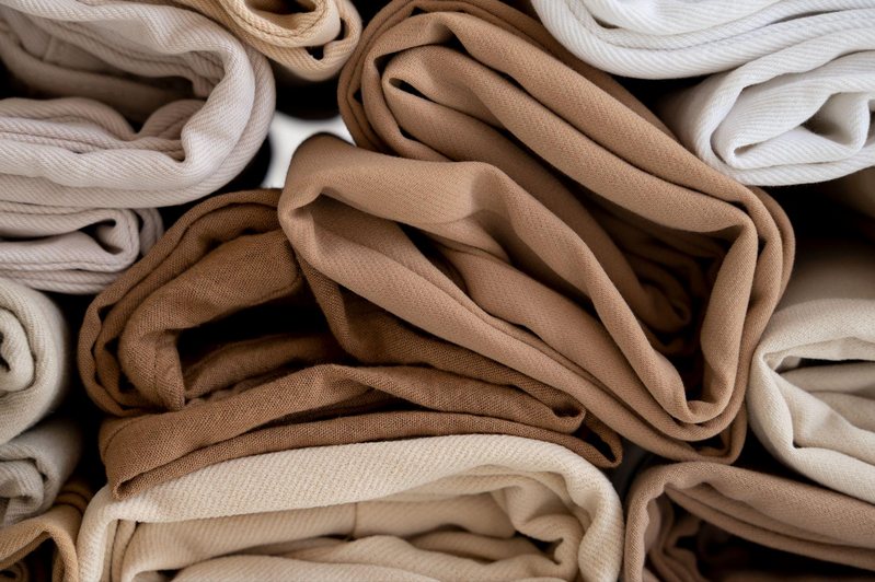 A pile of neatly folded textiles in a range of brown and cream tones.