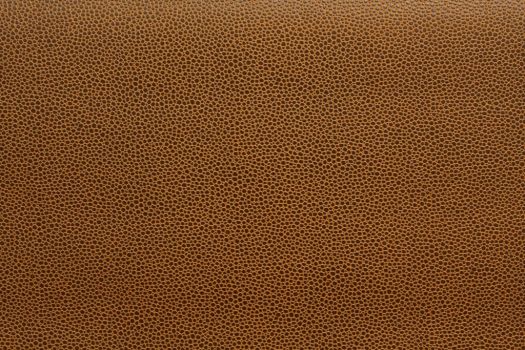 A close-up of a brown vinyl fabric with a textured pattern.
