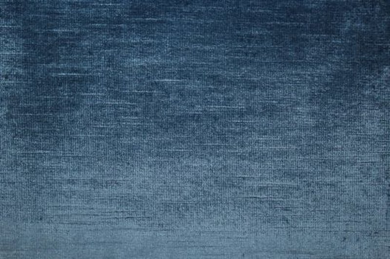 A close-up of a dark blue vintage fabric featuring a textured surface.