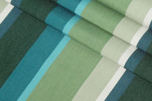 A close-up of a Sunbrella fabric in green, blue, and white stripes.