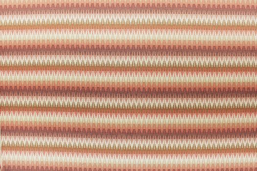 A close-up of an acrylic fabric alternating stripes of orange, brown, and white.