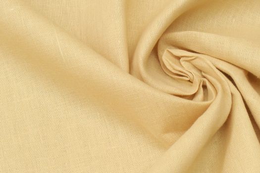 Close-up of linen fabric in mustard yellow color.