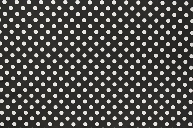A detailed image of black and white polka dot fabric featuring a repetitive pattern of circular dots.