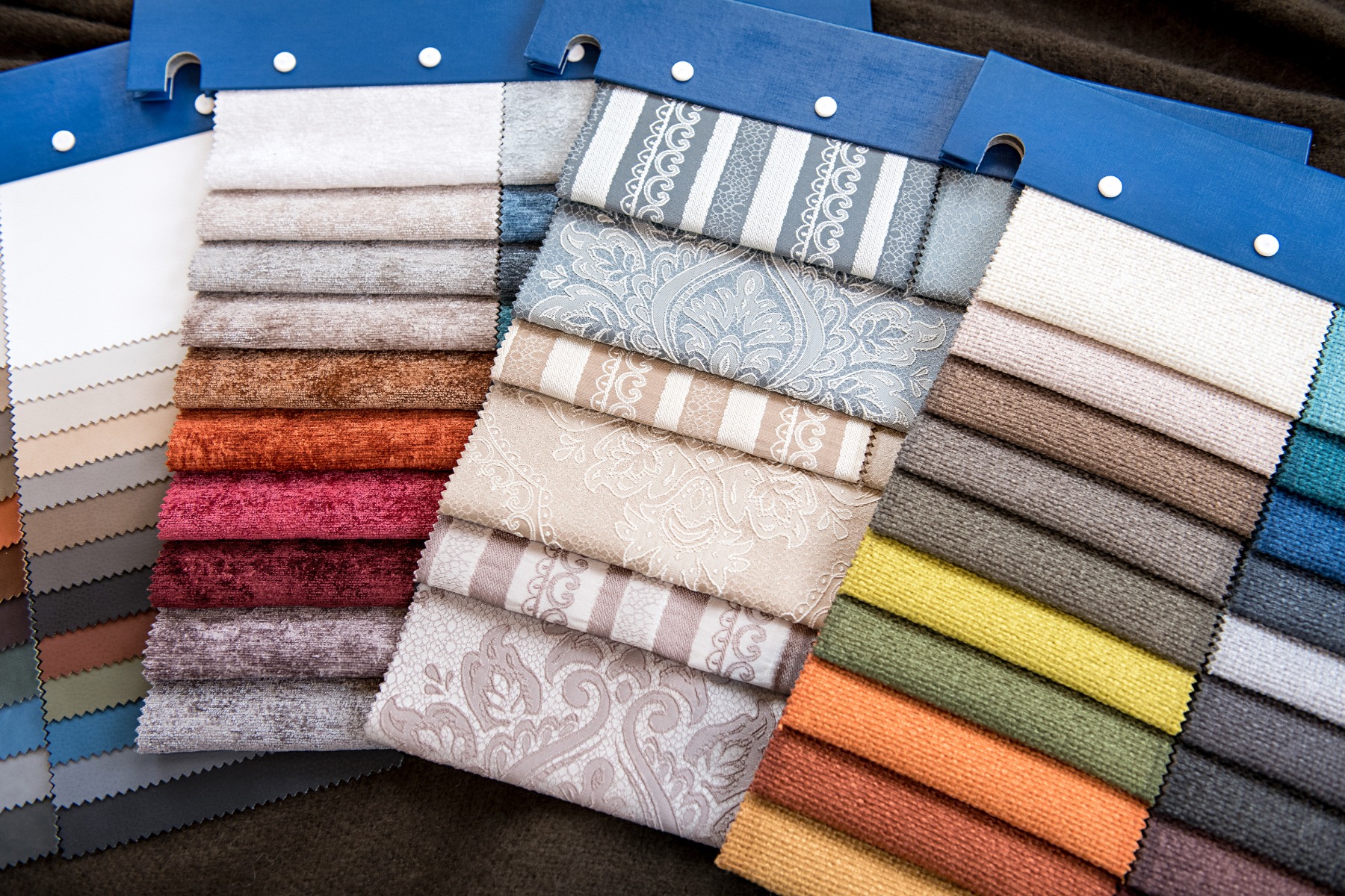 An assortment of fabric samples in colors ranging from black and white to beige, blue, and red.