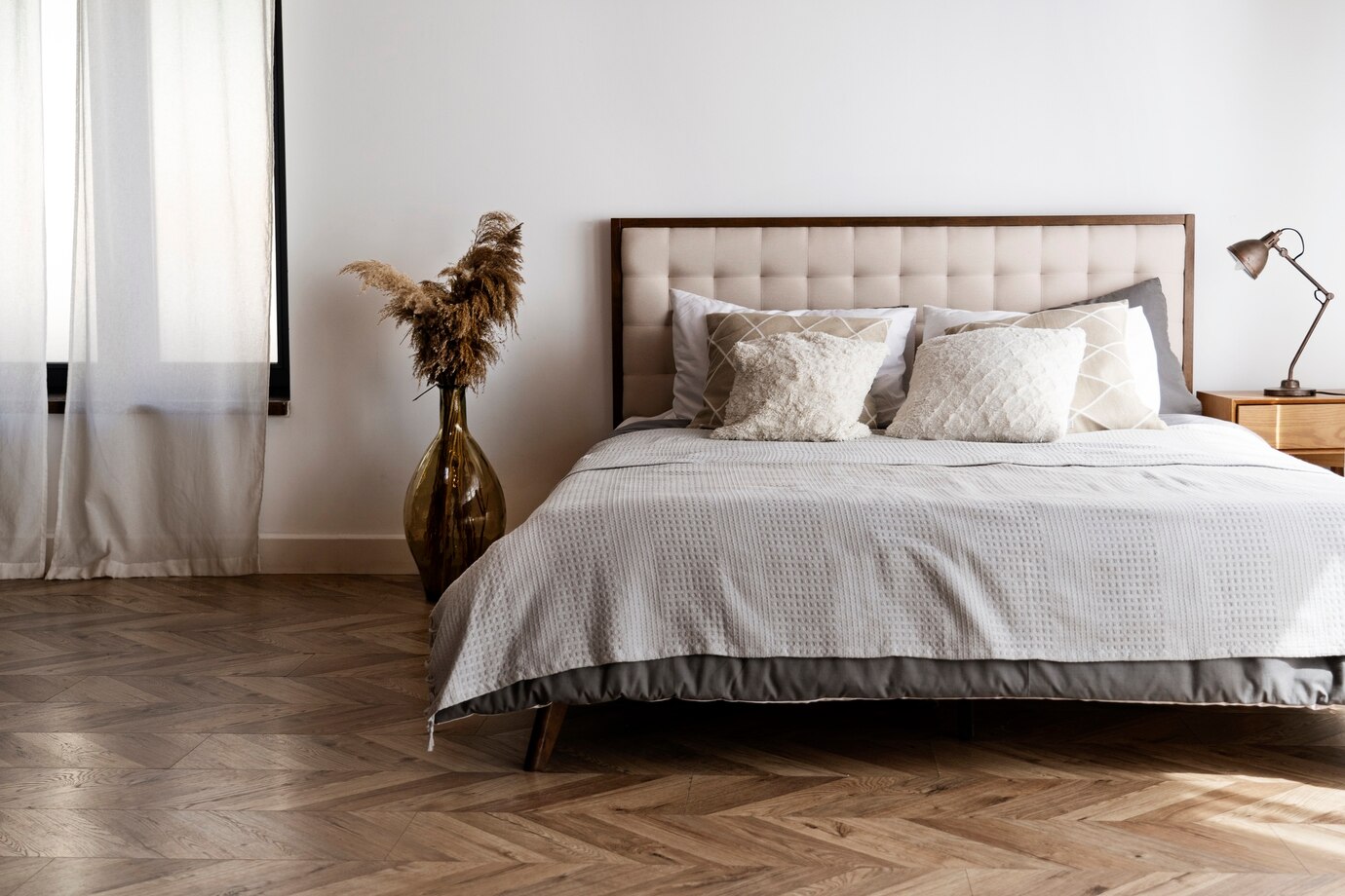 A minimalist bedroom in tones of gray and brown with the bed as the focal point.