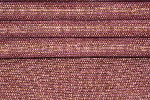 Close-up of a textured chenille fabric featuring bold purple and gold elements.