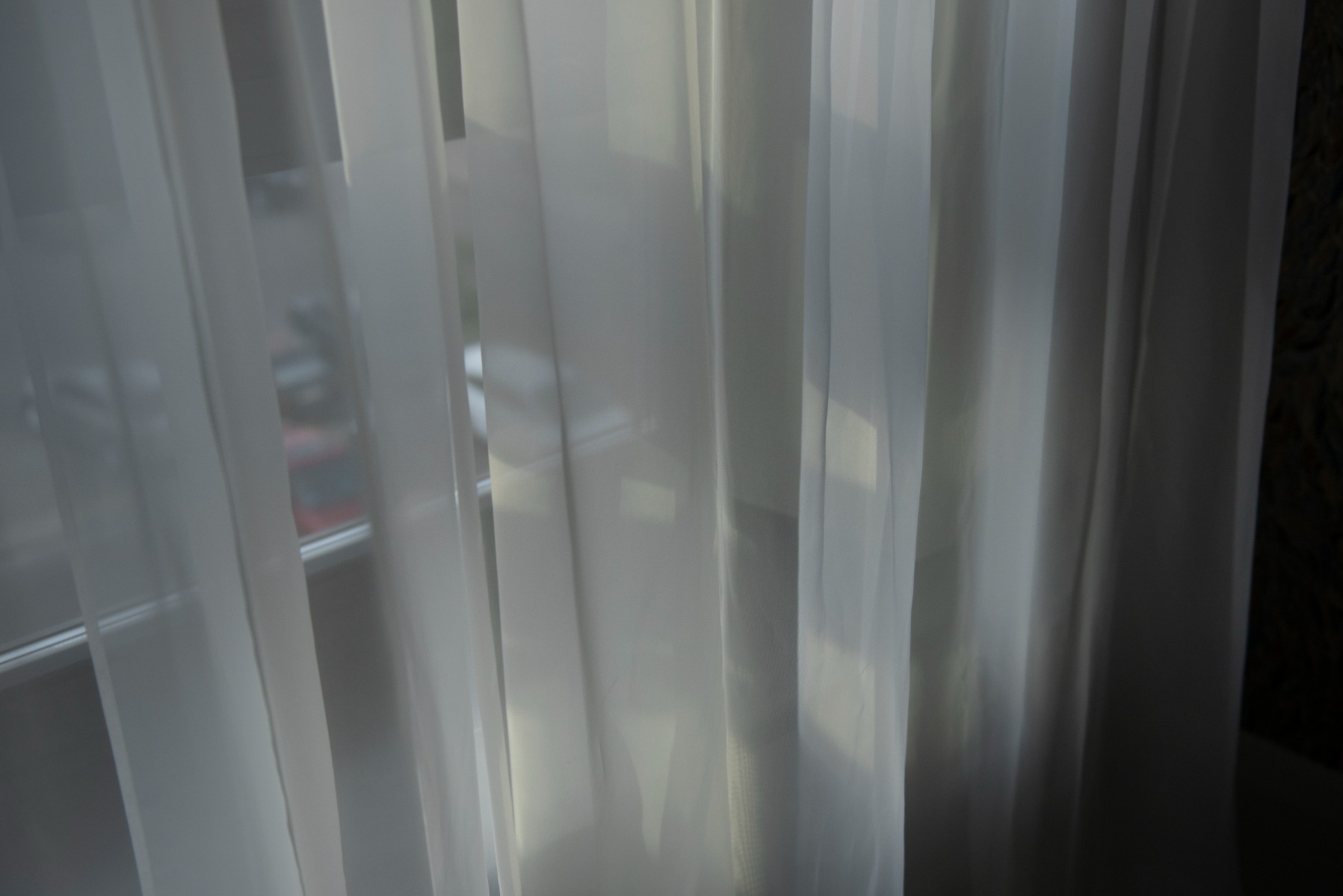 Soft rays of sunlight coming through a white nylon curtain from a window.