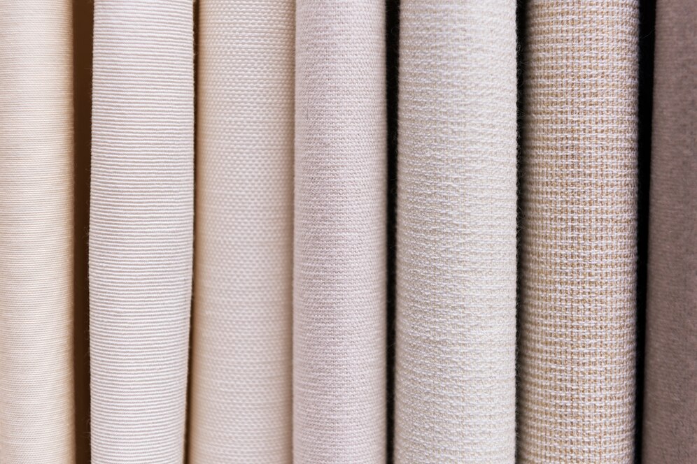 A selection of cotton canvas fabric samples in beige and light pink tones.