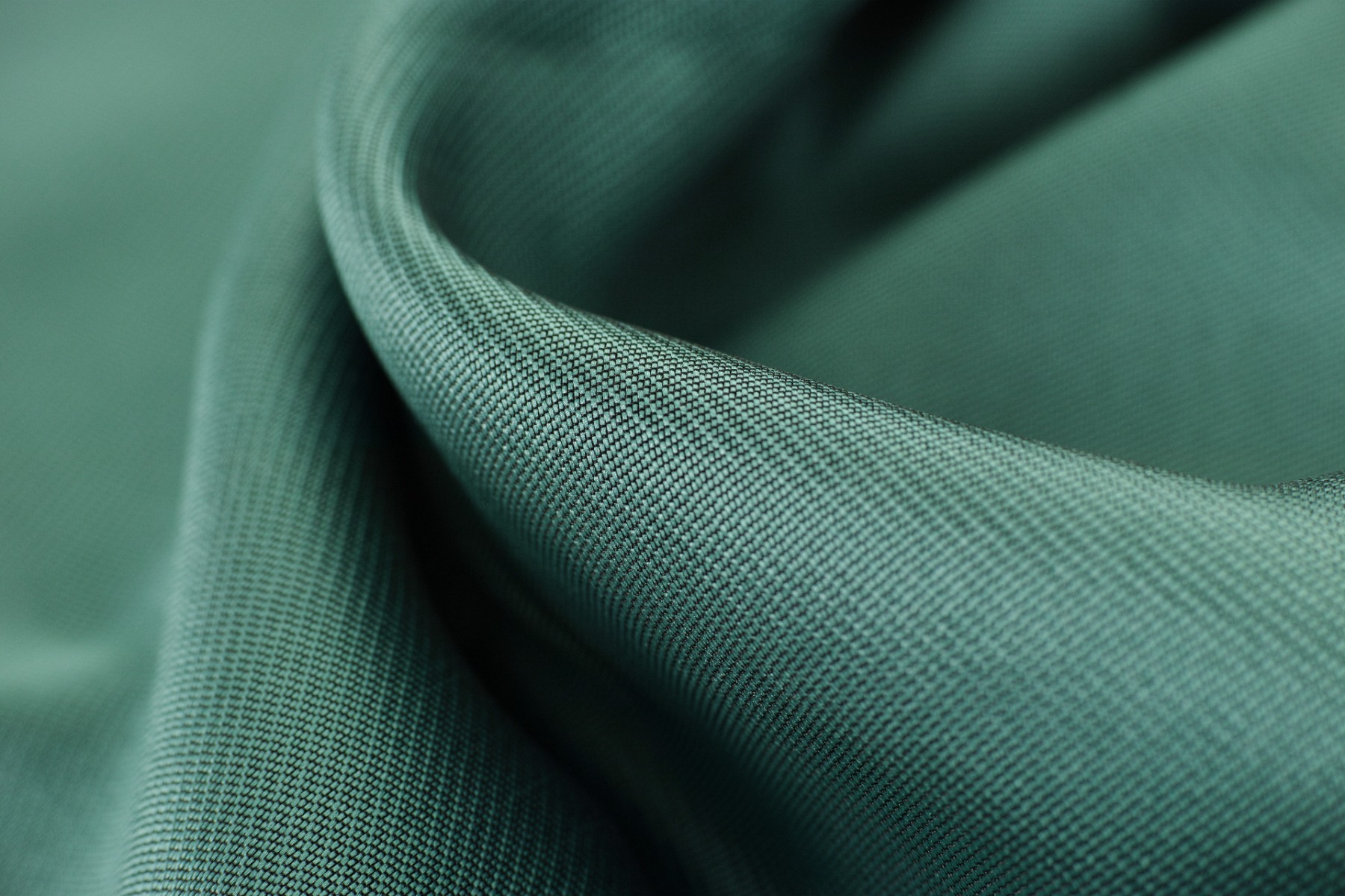 A close-up of a dark green olefin fabric.