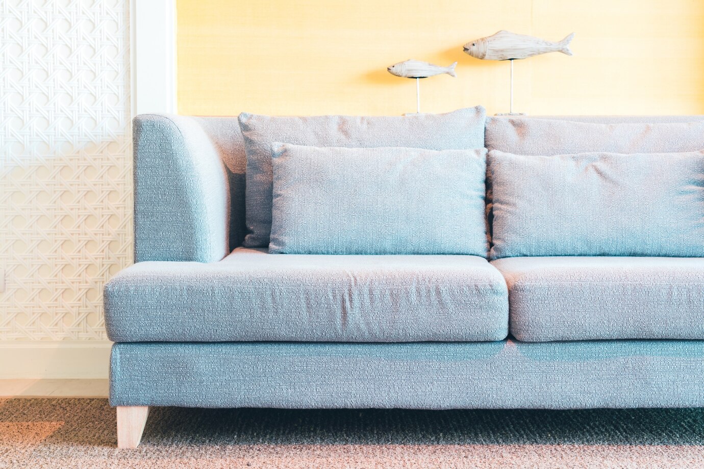 A blue microfiber couch with soft decorative pillows.