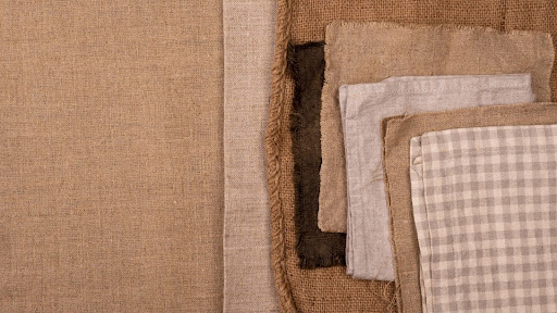 Flat lay of monochromatic assortment of textiles in brown and beige colors.