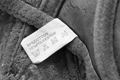 Close-up of a clothing label of fabric composition and care instructions.